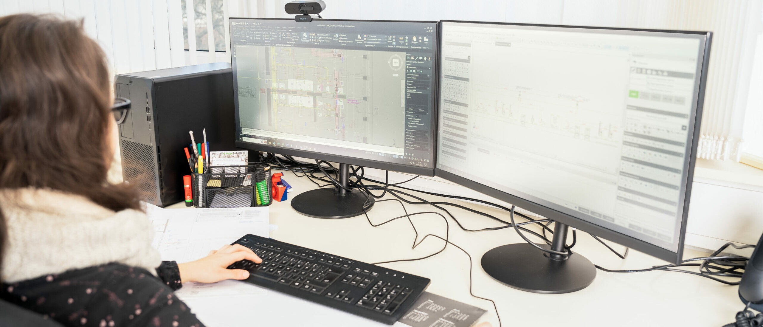 Mitarbeiterin Jessica arbeitet an ihrem Arbeitsplatz am Computer