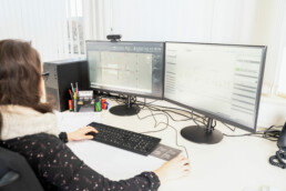 Mitarbeiterin Jessica arbeitet an ihrem Arbeitsplatz am Computer